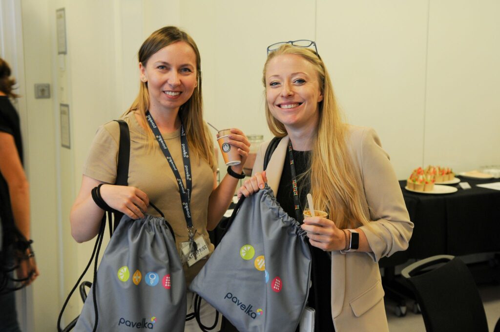 Two attendees holding Pavelka gym bags at a hybrid wellbeing event in Poland.