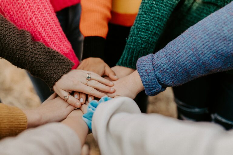 Group of people holding hands in unity, symbolizing resilience, teamwork, and emotional support