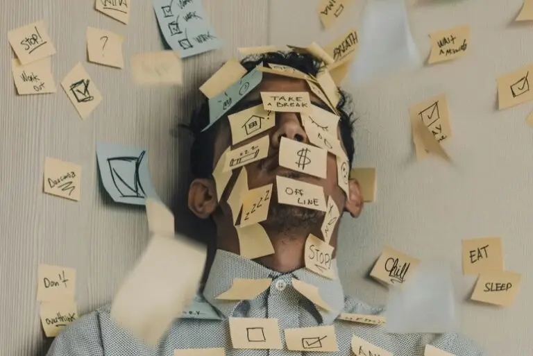 Overwhelmed young leader surrounded by sticky notes, highlighting the need for clear boundaries, expectations, and workload clarity.